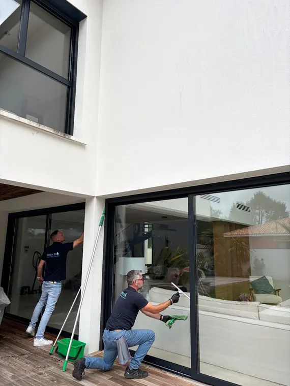 Agents nettoyant les baies vitrées extérieures d'une villa